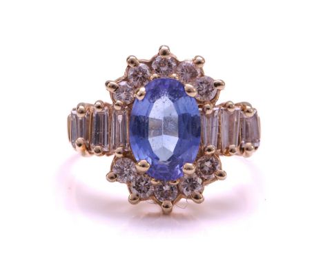 A tanzanite and diamond cluster ring and a pair of matching earrings; the ring comprises an oval tanzanite of 9.1 x 6.3 mm, c