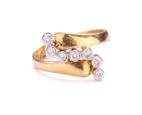 A diamond bypass ring in 18ct gold, containing seven brilliant-cut diamonds in collet setting, on a crossover shank, London i