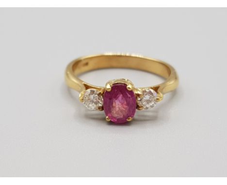 Ladies 18ct yellow gold ruby +diamond 3 stone ring, featuring a oval shaped ruby in the centre with a round brilliant cut dia