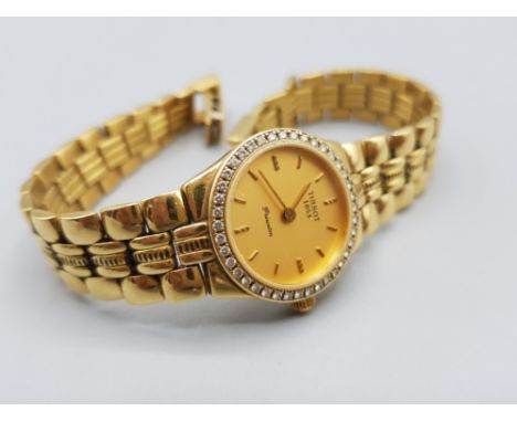 Ladies 18ct yellow gold Tissot watch featuring a champagne dial with gold baton hour markers , diamond bezel, complete with 1