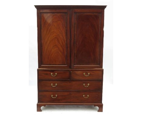 An 18th century mahogany linen press, having two panelled doors opening to reveal shelves, the base fitted with two short dra