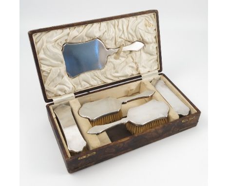 A cased hallmarked silver five piece dressing table set, with engine turned decoration,  comprising two pairs of brushes and 