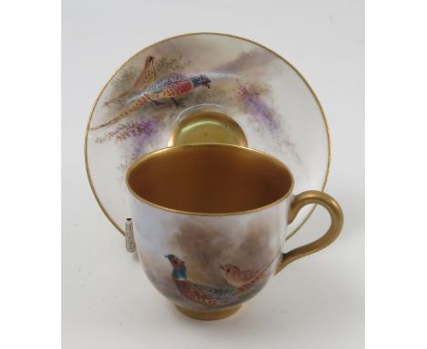 A Royal Worcester cabinet cup and saucer, hand painted with pheasants in a landscape to the exterior of cup and saucer, by Ja
