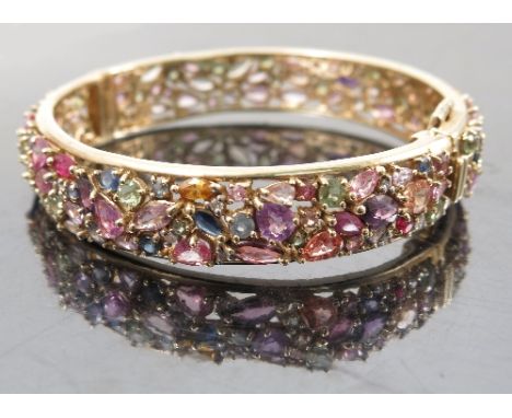 A multigem hinged bangle, including diamonds, peridot, amethyst, sapphire and topaz, internal diameter 6cm, gross weight 48.6