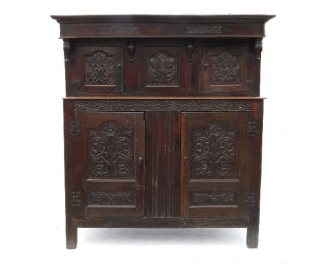 An Antique oak Continental court cupboard, the upper canopy carved with two doors flanking a central cupboard and 'RIW 1764' 