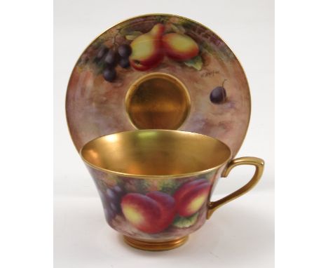 A Royal Worcester cabinet cup and saucer, hand painted to the exterior of the cup and the saucer with fruit to a mossy backgr