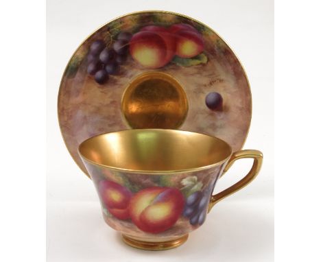 A Royal Worcester cabinet cup and saucer, hand painted to the exterior of the cup and the saucer with fruit to a mossy backgr