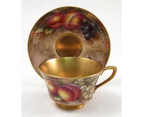 A Royal Worcester cabinet cup and saucer, hand painted to the exterior of the cup and the saucer with fruit to a mossy backgr