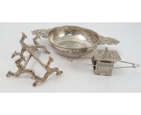 A white metal two handled wine taster, embossed with a female figure playing a harp, with pierced figural and scroll handles,