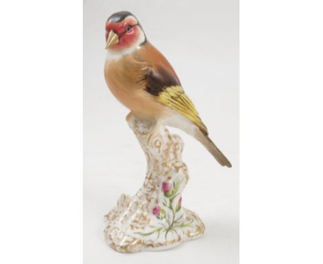 A Royal Worcester model, Goldfinch, on a gilt and white stump decorated with flowers, model number 2667 Condition report: goo