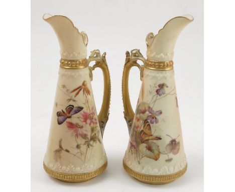 A pair of Royal Worcester blush ivory ewers, decorated with flowers and butterflies, bearing monogram for Edward Rayby, shape