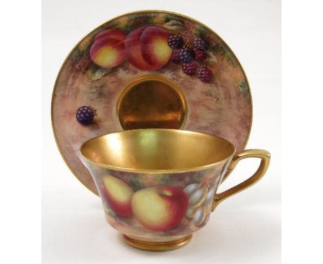 A Royal Worcester cabinet cup and saucer, hand painted to the exterior of the cup and the saucer with fruit to a mossy backgr