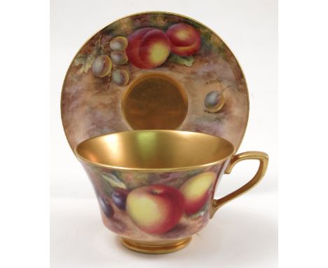 A Royal Worcester cabinet cup and saucer, hand painted to the exterior of the cup and the saucer with fruit to a mossy backgr