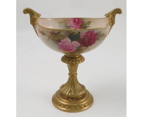 A Royal Worcester centre piece, of oval form, decorated with red and pink roses by E M Fildes, with gilt handles and gilt ped