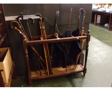 Edwardian period long oak umbrella/stick holder (lacking tray base), holding nine assorted walking sticks/canes including one