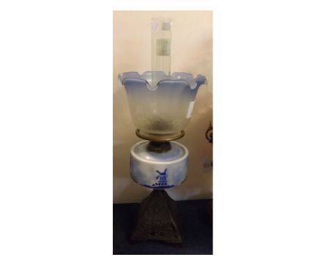 Victorian cast iron based oil lamp with blue and white glass windmill decorated font, etched blue crimped shade, 21ins tall 