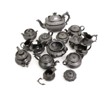 Early 19th century and later black basalt tea wares, mostly with relief or engine-turned bodies, including a large teapot wit