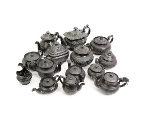 Early 19th century and later black basalt tea wares, mostly with relief or engine-turned bodies, including teapots, bachelors