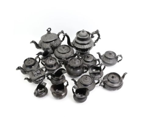 Early 19th century and later black basalt tea wares, mostly with relief or engine-turned bodies, including a floral moulded t