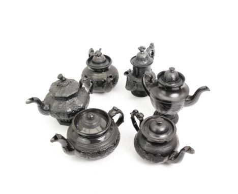Six early 19th century and later black basalt tea and coffee pots, mostly with relief or engine-turned bodies, including a Cy