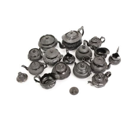 Early 19th century and later black basalt tea wares, mostly with relief or engine turned bodies, including bachelors teapots,