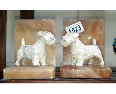 A pair of art deco book ends surmounted dogs