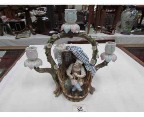 A continental porcelain candelabra depicting a shoe mender
