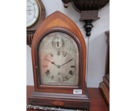 An arched top mahogany inlaid chiming mantel clock with silvered dial