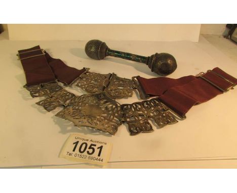 A vintage belt with white metal fittings and an old babies rattle