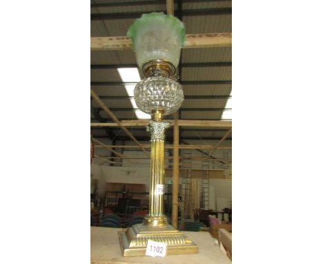 A Corinthian column oil lamp with brass base, glass font and acid etched green shade