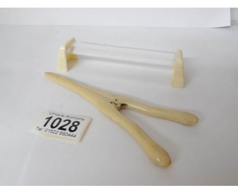 A pair of ivory glove stretchers and one other item