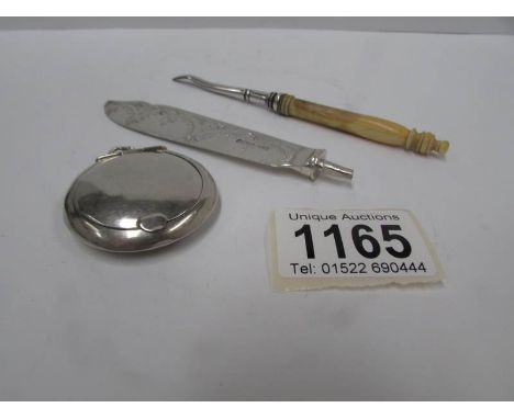 A silver pendant pill box, a silver knife blade and a white metal item