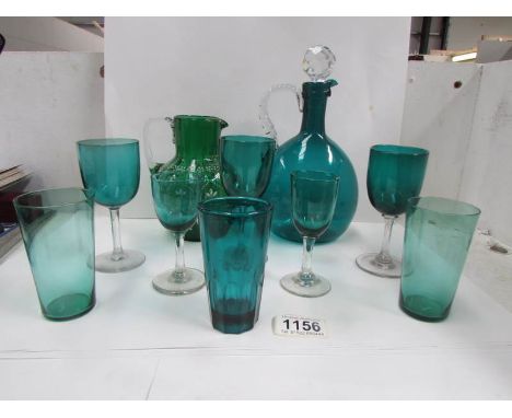 A green glass decanter, a green glass hand painted jug and a quantity of green glass drinking glasses
