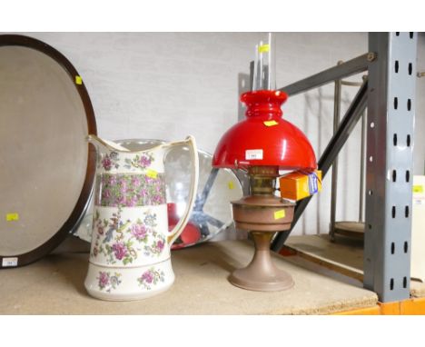 Aladdin oil lamp with red glass shade and ceramic decorative jug, 34 cm high