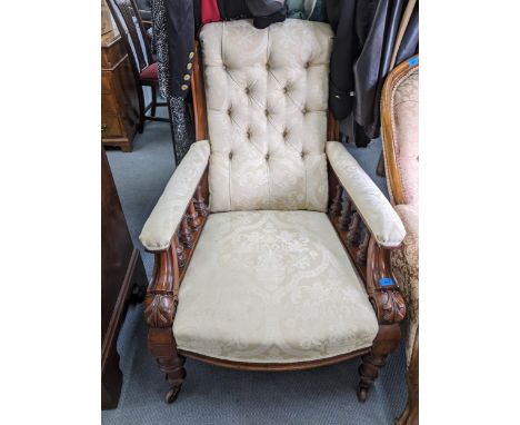 A late Victorian carved mahogany deep-seated button back upholstered armchair, open arms with turned gallery frame, upholster