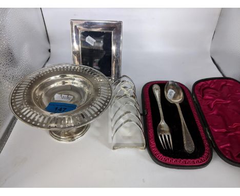 Small silver items to include early 20th Century toast rack, a pedestal bonbon dish with a pierced rim, a presentational fork