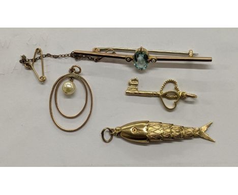 Four pieces of 9ct gold jewellery to include a bar brooch set with a garnet, a pendant fashioned as a fish, a heart, key pend