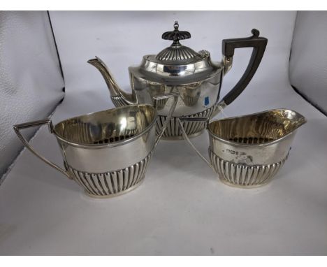 A silver three part bachelors tea set with a ribbed design comprising of a teapot, twin handled sugar bowl and a milk jug, Sh