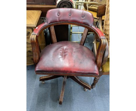 A reproduction red leather button back upholstered swivel captains office armchair 