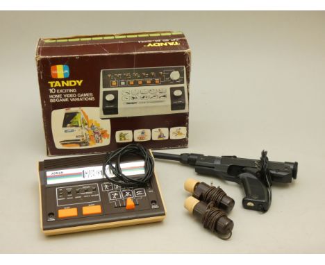 A boxed Tandy (60-9005A), with instrustion manual, power leads, a combination game rifle and pistol, and controllers, togethe