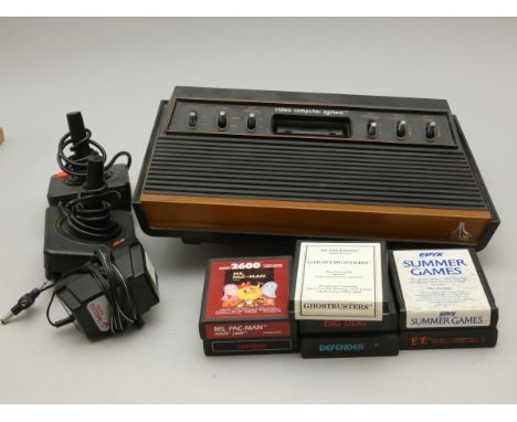 An Atari 2600 "woody" console, together with two joysticks, power cable and seven games, including Ghostbusters, Ms. Pac-man,
