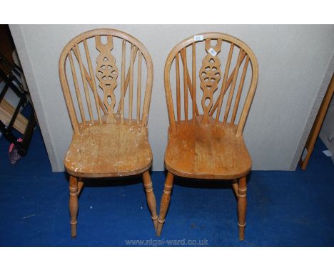 A pair of light-wood wheel-back side chairs. 