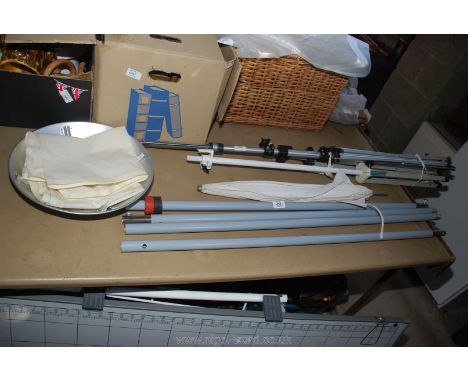 Two photographic lighting tripods and flash/light reflectors.