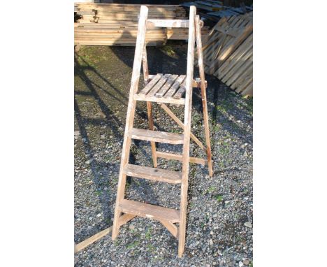 A wooden three-tread decorator's step ladder.