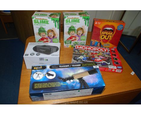 A child's telescope, Nintendo Monopoly game, speak out game, a virtual reality headset and slime soaker games.