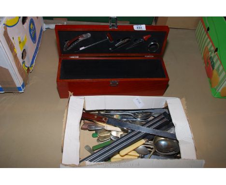 A quantity of cutlery and a dark-wood wine bottle box with sommelier's/bar-tender's tools.