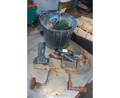 A bucket of various nails, hand braces, tools, etc.,