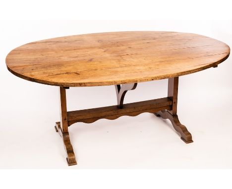 A French fruitwood table, the oval tilt top on folding trestle type base and splay feet, 168cm x 121cm CONDITION REPORT: Top 