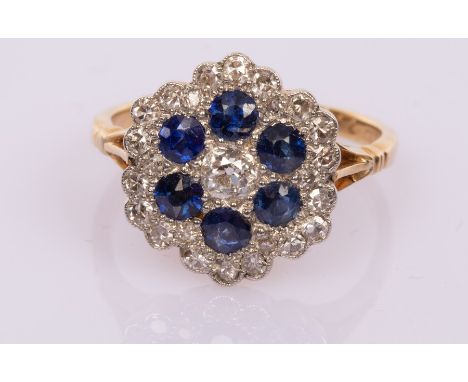 A diamond and sapphire flowerhead cluster ring, the central diamond to a surround of six sapphires with an outer border of di