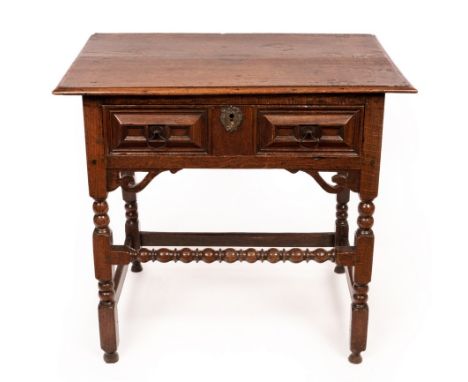 A Charles II Guernsey oak side table with cushion panelled drawer to the frieze, on bobbin turned legs united by square stret